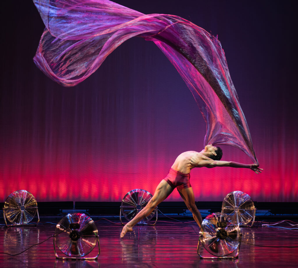 Dancer on a stage with a flowing cloth in their hands